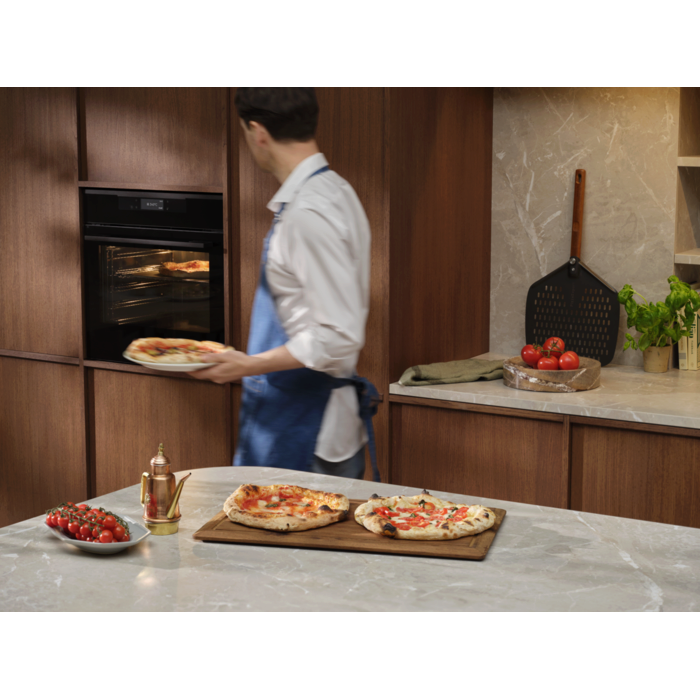 Person with the pizza expert oven and Neapolitan pizzas 