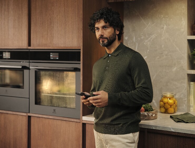 Mees seisab köögis ja hoiab käes telefoni.